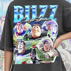 May include: Dark gray t-shirt featuring a graphic of Buzz Lightyear from Toy Story. The design includes the text "BUZZ LIGHTYEAR" in a blue, 3D font, and multiple images of the character in his spacesuit. The shirt is labeled "COMFORT COLOR PEPPER".