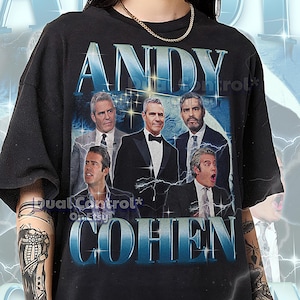 Puede incluir: Camiseta unisex negra con un gráfico de Andy Cohen y el texto "ANDY COHEN" en una fuente degradada azul. La camiseta tiene un diseño de estilo vintage con un collage de fotos de Andy Cohen. El texto en la parte inferior de la camiseta dice: "EL PRIMER MODELO LLEVA UNA CAMISETA 2XL. ESTA CAMISETA UNISEX ES FIEL A LA TALLA. PARA UN LOOK DE GRAN TAMAÑO, SIMPLEMENTE SELECCIONE UNA TALLA O DOS TALLAS MÁS GRANDES QUE SU TALLA HABITUAL. CONSULTE LA TABLA DE TALLAS (MEDIDA SOBRE UNA SUPERFICIE PLANA) PARA UN TAMAÑO EXACTO."