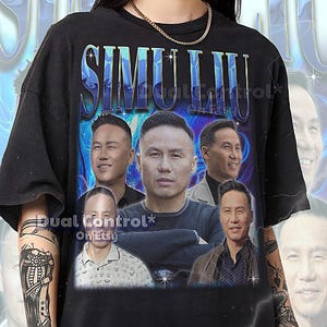 以下が含まれることがあります： 青と白のグラデーションフォントで「SIMU LIU」という名前がプリントされた黒いTシャツ。シャツには男性の複数の画像が表示されています。「Dual Control on Etsy」というテキストも表示されています。