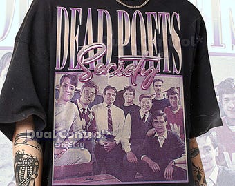 May include: Black unisex t-shirt featuring the text "DEAD POETS Society" in a purple and white design. The shirt has a vintage-style image of a group of men. The model is wearing a 2XL shirt.