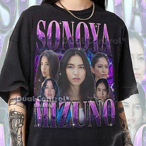 Op de afbeelding: Zwart unisex T-shirt met de naam "SONOVA MIZUNO" in een paarse retro-stijl lettertype. Het ontwerp bevat meerdere afbeeldingen van een vrouw. De tekst "Dual Control* On Etsy" is ook zichtbaar.