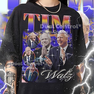 Pode incluir: Camiseta unissex preta com um design gráfico com a palavra "TIM" em um esquema de cores gradiente. O design inclui retratos de vários homens de terno e a palavra "Walz" em itálico. A camiseta também tem o texto "Dual Control* On Etsy".