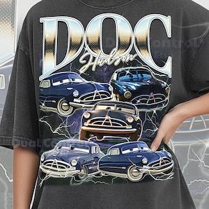 May include: Dark gray Comfort Colors t-shirt featuring a graphic of Doc Hudson from the movie Cars. The design includes the text "DOC Hudson" in a stylized font, with multiple images of the character and lightning bolts.