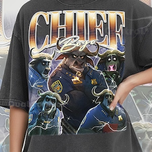 Puede incluir: Camiseta gris oscuro con un gráfico de un toro con uniforme de policía y el texto "CHIEF Bogo". El diseño incluye rayos y las palabras "COMFORT COLOR PEPPER" en la parte inferior. La camiseta tiene un aspecto vintage.