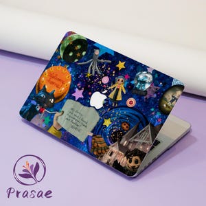 May include: A laptop skin with a dark blue background, covered in colourful illustrations. The design includes a black cat, stars, a pumpkin, and the text "Welcome home!". A handwritten note reads "Hey Jonesy... Look what I found... Look familiar? Wybie."