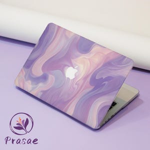 May include: A laptop with a purple, pink, and white swirling design on the lid. The Apple logo is visible. The laptop is open, revealing the keyboard. The brand name "Prasae" is displayed with a floral logo.