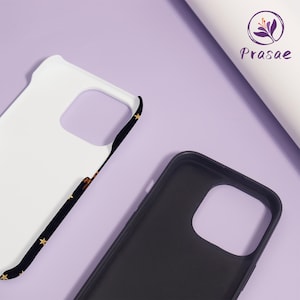 May include: Two phone cases, one white and one black, are shown against a purple background. The white case has a black border with gold stars. The black case is plain. The brand name "Prasae" is visible in the upper right corner.