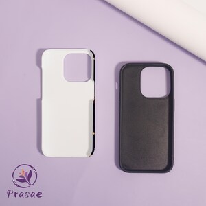 May include: Two phone cases, one white and one black, are shown on a light purple surface. The white case has a black border with gold stars. The black case is open, revealing the interior. The brand logo is visible in the lower left corner.