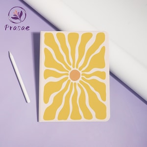 May include: A notebook with a yellow flower design on a cream background. The flower has a peach-colored center and radiating petals. A white stylus rests on a purple surface next to the notebook. The brand name "Prasae" is in the upper left corner.