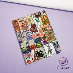May include: A rectangular notebook covered in a collage of colorful postage stamps. The stamps feature various designs, including flowers, fruit, animals, and portraits. The notebook is on a purple surface.