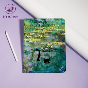 May include: A notebook featuring a water lilies painting with a black cat illustration. The cover art is inspired by Monet's style, with a black cat's head and tail emerging from the water. A white stylus is on the left.