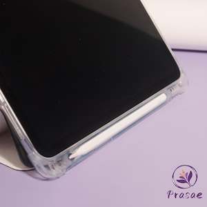 May include: A clear phone case with a white stylus. The phone screen is black. The case is on a light purple surface. The logo for Prasae is in the bottom right corner.