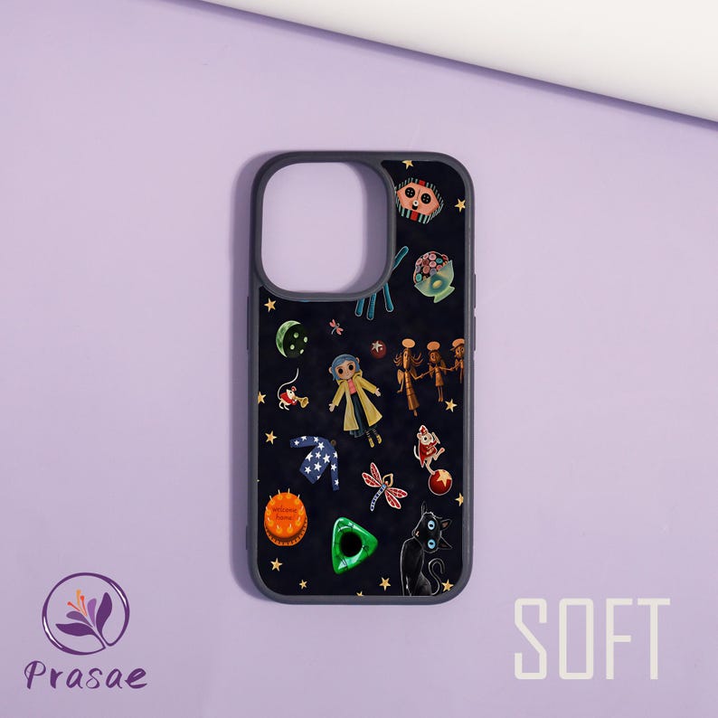 May include: A black phone case with a dark grey border, decorated with cartoon characters, stars, and other whimsical elements. The word "SOFT" is printed in white on the bottom right. The case has cutouts for the camera and buttons.