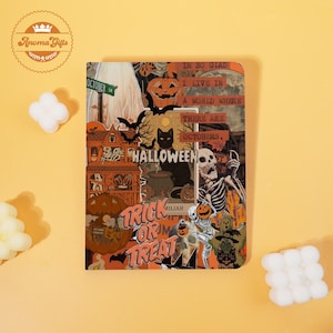 May include: A Halloween-themed notebook with a collage of spooky illustrations. The design includes a haunted house, jack-o'-lanterns, bats, and the text "Halloween" and "Trick or Treat". The color palette features orange, black, and white.