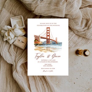 May include: Wedding invitation featuring a watercolor illustration of the Golden Gate Bridge in San Francisco. The invitation includes the names "Taylor & Gavin", event details, and RSVP information. The design is on a white background.