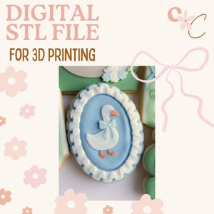 Può includere: File STL digitale per la stampa 3D. L'immagine presenta un biscotto decorato con un centro ovale azzurro, un'oca bianca con un fiocco e un bordo bianco a balze. Il testo "DIGITAL STL FILE FOR 3D PRINTING" è in alto.