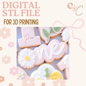 May include: Pink iced biscuits with white and green details, featuring a daisy, the word "one", and the name "Pia". The image also includes the text "DIGITAL STL FILE FOR 3D PRINTING".