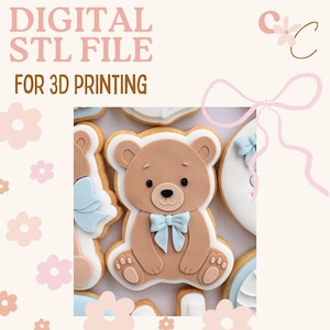 May include: Close-up of decorated biscuits, including a teddy bear with a blue bow tie. The biscuits are light brown with white and blue accents. Text at the top reads "DIGITAL STL FILE FOR 3D PRINTING".