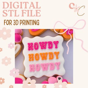 May include: A digital STL file for 3D printing, featuring a decorated cookie with the word "HOWDY" in pink and orange icing. The image has a light pink and cream color scheme with floral accents.