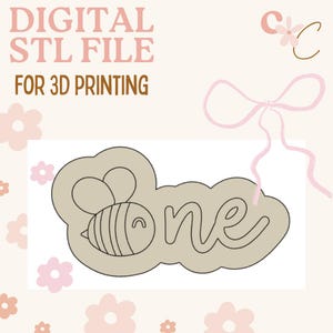 May include: A digital STL file for 3D printing, featuring a bee design with the word "one". The design is in a light beige color, with the text in a handwritten style. The background is a light peach color with floral accents.
