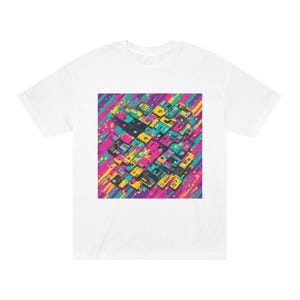 Op de afbeelding: Een wit t-shirt met korte mouwen en een centrale grafische print van talloze gestapelde cassettebandjes in levendige tinten roze, geel en taling. De achtergrond van de afbeelding bestaat uit diagonale strepen in bijpassende neonkleuren.