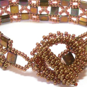 Könnte beinhalten: Handgefertigtes Armband mit geometrischem Design aus quadratischen und runden Perlen in Bronze- und Kupfertönen. Das Armband hat einen einzigartigen Verschluss und eignet sich für den Alltag oder besondere Anlässe.