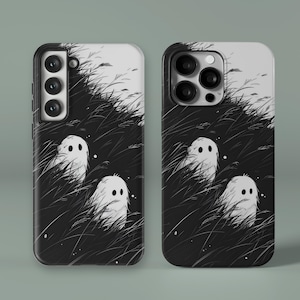 May include: Black and white phone cases featuring a whimsical illustration of three cartoon ghosts in tall grass. The design has a minimalist aesthetic with a grayscale color palette, perfect for Halloween or spooky season.