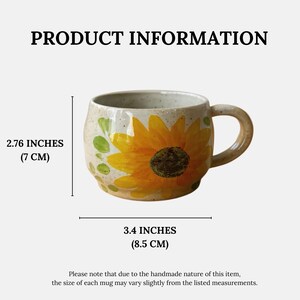 Pu&ograve; includere: Tazza in ceramica con un motivo di girasole dipinto a mano. La tazza &egrave; alta 7 cm e larga 8,5 cm. Presenta accenti gialli, verdi e marroni su uno sfondo beige. Il testo "PRODUCT INFORMATION" &egrave; in alto.