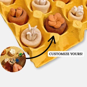 Könnte beinhalten: Ein gelber Eierkarton mit kleinen Keramik-Pflanzgefäßen, die mit verschiedenen Pflanzen gefüllt sind. Die Pflanzgefäße sind kreisförmig angeordnet. Der Text "CUSTOMIZE YOURS!" steht auf dem Karton.