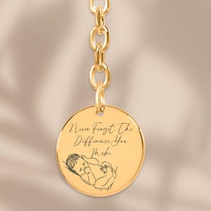 May include: Gold keychain with a round charm that says "Never forget the difference you make" and a small line drawing of a baby.
