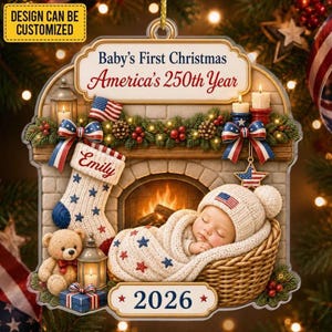 May include: A decorative Christmas ornament featuring a fireplace scene with a sleeping baby in a basket, a stocking labeled Emily, a teddy bear, and a gift. The text reads Baby's First Christmas, America's 250th Year, and 2026. It includes red, white, and blue accents.
