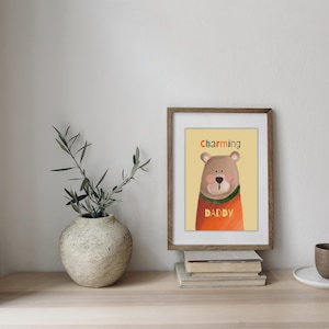 Può includere: Una stampa incorniciata con un'illustrazione di un orso bruno che indossa un maglione arancione. Il testo "charming daddy" è scritto sotto l'orso.