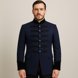 May include: A navy blue military-style jacket with a high collar and black trim. The jacket features decorative black rope detailing and silver buttons down the front. The cuffs are black velvet. A classic, tailored garment.