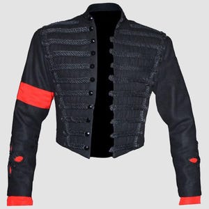 May include: A black jacket with a high collar and a row of buttons down the front. The jacket has a unique design with rope-like trim around the edges. The sleeves have red stripes on the upper arms.