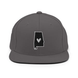 May include: A charcoal gray baseball cap featuring an embroidered outline of the state of Alabama in black, with a white heart in the center. The cap has a flat brim and a structured fit, suitable for casual wear.