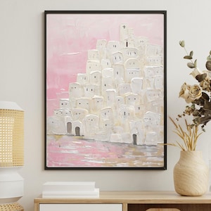 May include: A painting of a white city with a pink sky. The city is made up of many small, white buildings with windows and doors. The sky is a soft pink color with a few clouds. The painting is framed in black.