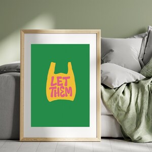 May include: A framed art print with a yellow plastic bag graphic and the pink text "LET THEM". The artwork is set against a vivid green background. The frame is a light wood colour, adding a natural touch to the modern design.