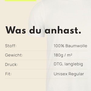 May include: A white t-shirt with product information text in German. The text includes '03 / Material', 'Was du anhast.', 'Stoff: 100% Baumwolle', 'Gewicht: 180g / m&sup2;', 'Druck: DTG, langlebig', 'Fit: Unisex Regular', and 'FRIEDAFUNKEL - BERLIN' at the bottom.