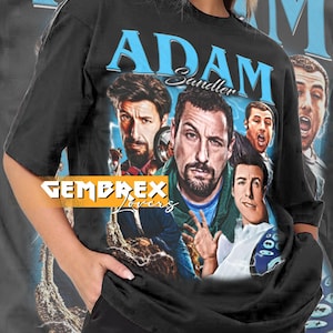 May include: Black unisex t-shirt featuring a graphic of Adam Sandler with the text "ADAM Sandler" in blue. The shirt has a vintage design with multiple images of the actor. The text "GEMBREX Lovers" is also visible.