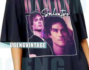 May include: Black oversized t-shirt featuring a graphic of Damon Salvatore with the text "DAMON Salvatore" in a purple and white design. The shirt also has the text "UGENGVINTAGE" and "ENG".