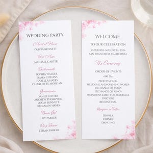 May include: Two white wedding program cards with pink floral accents and gold trim. The left card reads "Wedding Party" with names. The right card says "Welcome" and lists the ceremony details.