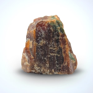 May include: A natural gemstone with a rough, uneven surface. The stone displays a blend of brown, orange, and green hues. The gemstone is set against a white background.