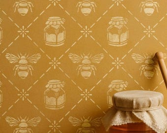 May include: Mustard-colored wall with a repeating pattern of bees, honey jars, and flowers. A jar of honey with a cloth cover and a wooden honey dipper are in the foreground. The pattern is in a lighter shade of yellow.