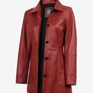 May include: A red leather jacket featuring a classic collar, long sleeves, and a front button closure with four black buttons. The interior is lined with black fabric and includes a rectangular label at the neck that reads Real Leather.