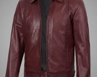 Puede incluir: Chaqueta de cuero burdeos con cuello y cierre de cremallera frontal. La chaqueta tiene un diseño clásico con forro interior negro y un corte entallado. Las mangas tienen un detalle de puño abotonado. La chaqueta es de color liso.