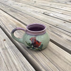 May include: A set of three ceramic mugs with a speckled, matte finish in cream, light grey, and dark grey. Each mug has a simple, minimalist design, suitable for coffee or tea.