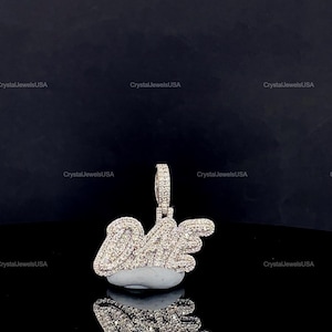 May include: A diamond-encrusted pendant spelling out "Dope" with wing accents. The pendant is silver-toned and set with numerous small, sparkling stones. The pendant is displayed on a reflective surface.
