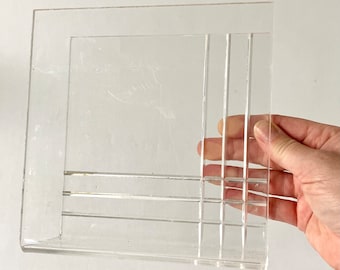 Op de afbeelding: Een transparante acryl organizer met een rasterpatroon. De organizer heeft een rechthoekige vorm en is ontworpen om items rechtop te houden.