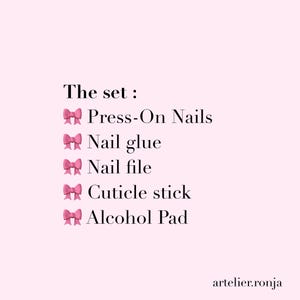 May include: A pink background with the text "The set: Press-On Nails, Nail glue, Nail file, Cuticle stick, Alcohol Pad." The text is in black, with pink bow emojis. The website artelier.ronja is at the bottom.
