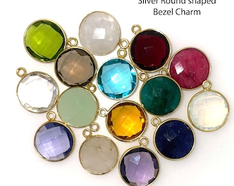 May include: Assortment of 14mm round bezel charms in various colors, including green, white, red, pink, blue, brown, yellow, and purple. The charms are made of gold over sterling silver.